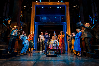 FOL-WInter's Tale Sicily Party A birthday party with 8-year-old Mamillius riding a cart surrounded by cheering guests with a gold framed door towering on the back wall.